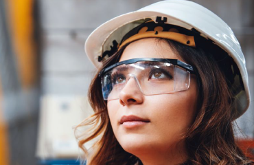 Lady in a hard hat and protective glasses