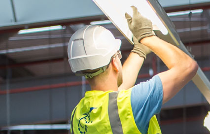 Man in a hard hat working on a light