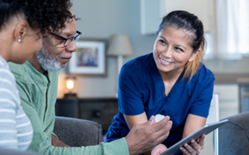 Female nurse helping an older man on ipad