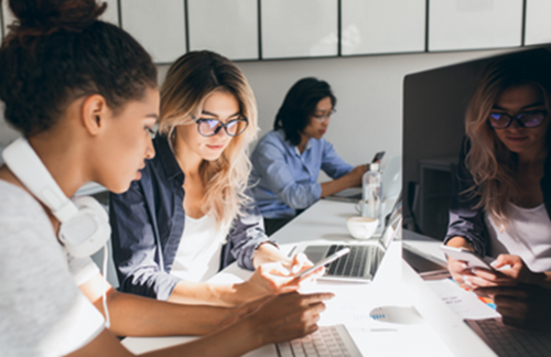 Blonde Woman Working With Colleagues At Computer