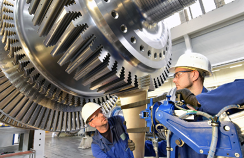 Two Men Working On Large Machinery